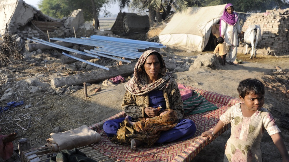 A mother and her children outside a temporary shelter in rural Pakistan